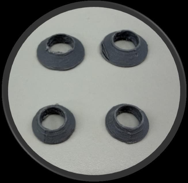 Four printed PLA cones on a white disc, visibly squashed and uneven around their bores.
